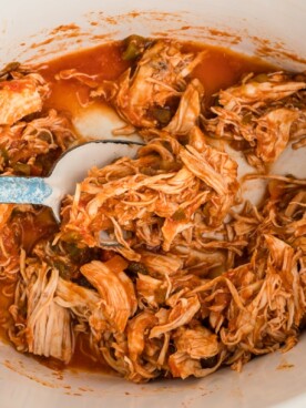 salsa chicken in a crockpot with spoon in it.