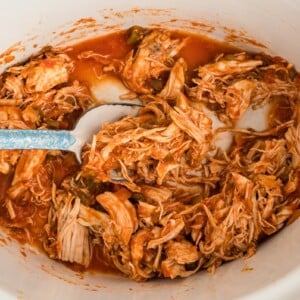 salsa chicken in a crockpot with spoon in it.