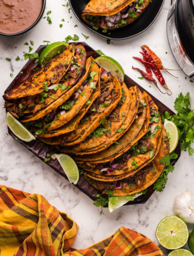 many birria tacos on a platter.