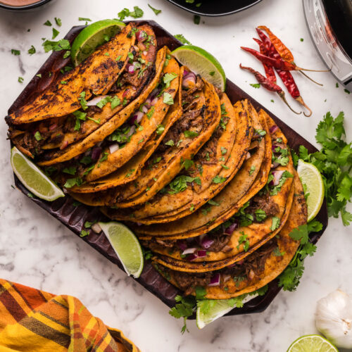 many birria tacos on a platter.