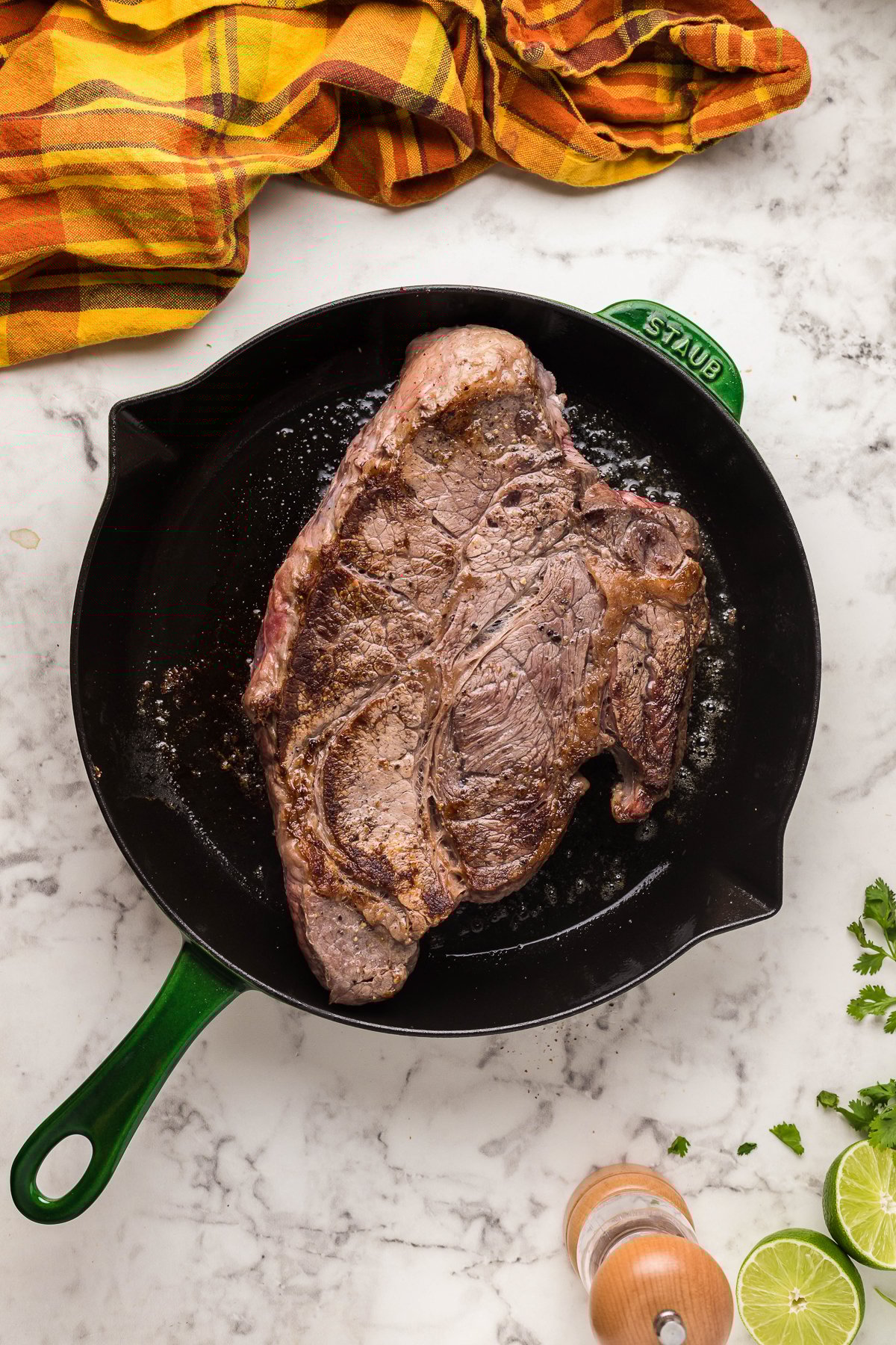 chuck roast being cooked in a skillet. 