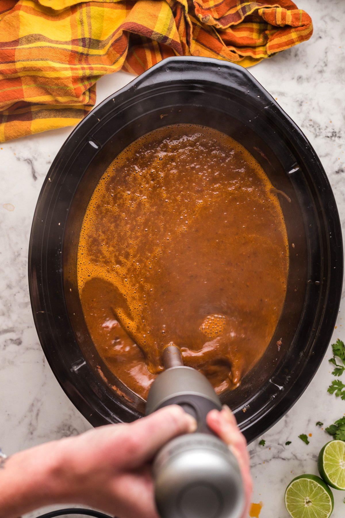 The birria sauce (or conumme) being blended up with an immersion blender.
