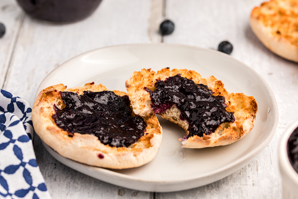 English muffin with blueberry butter on it.