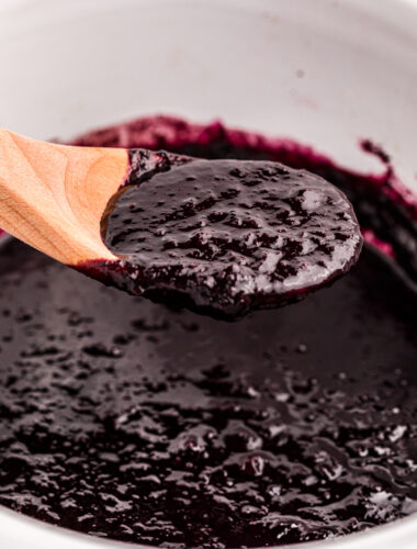 Blueberry butter on a spoon coming from a slow cooker.