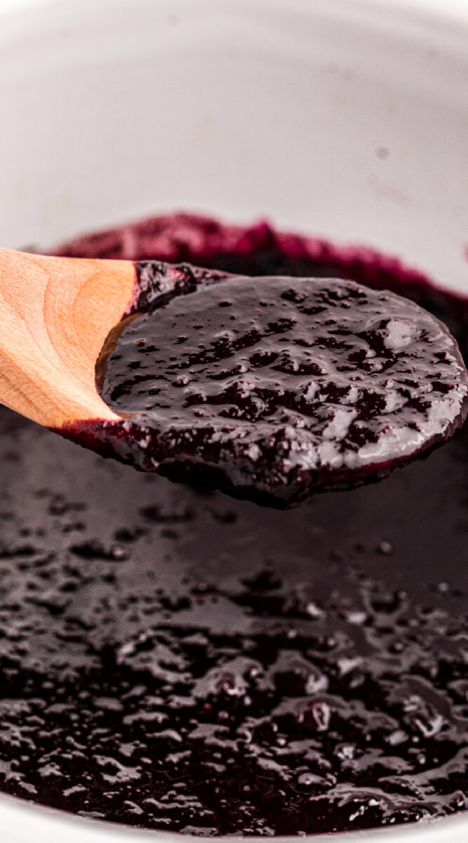 long image of blueberry butter on a spoon.