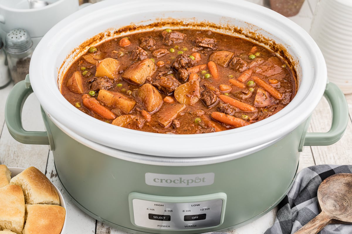 Done cooking beef stew in a green slow cooker.