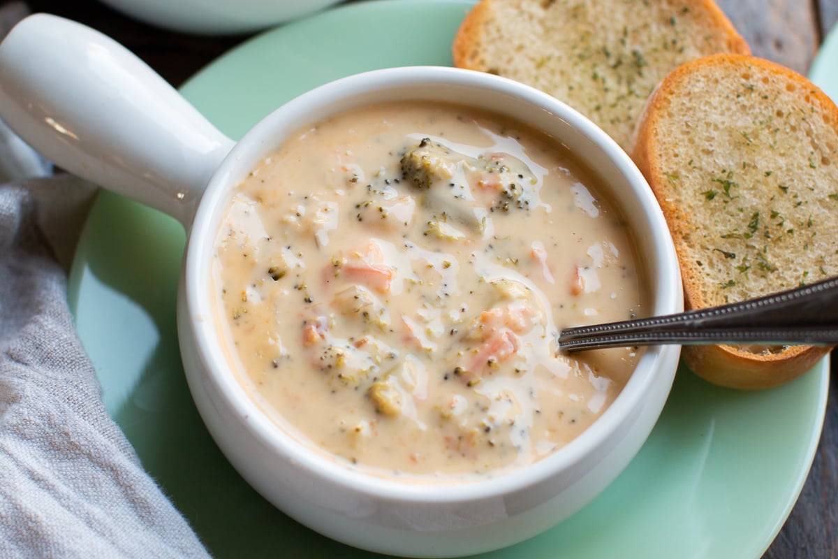 bowl of broccoli cheese soup with spoon in it.