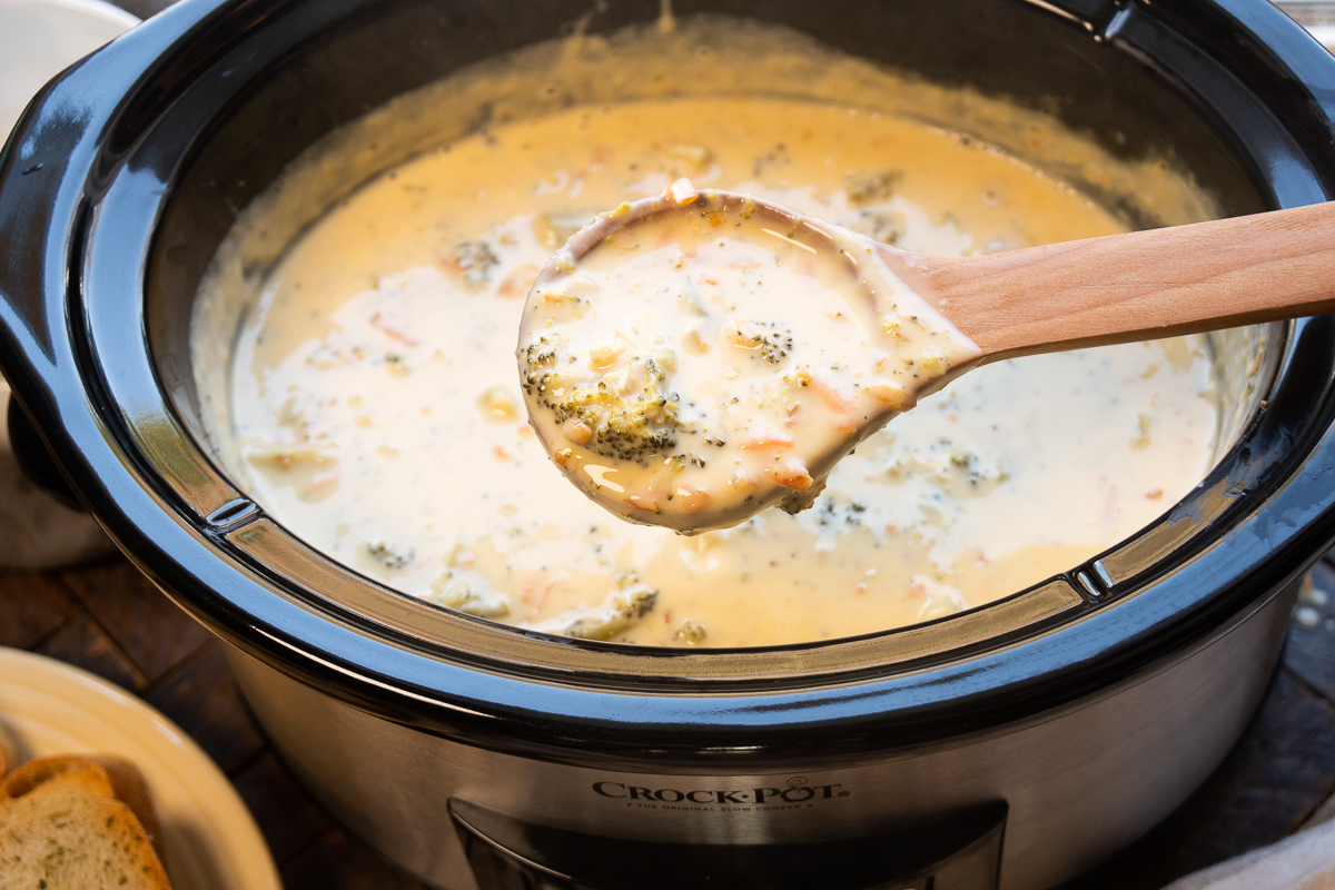 broccoli cheese soup in a crockpot and on a spoon.
