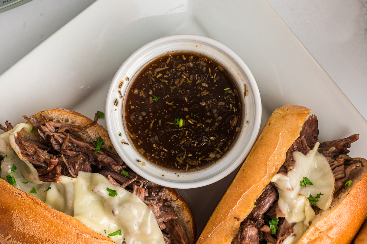 au jus and two french dip sandwiches.