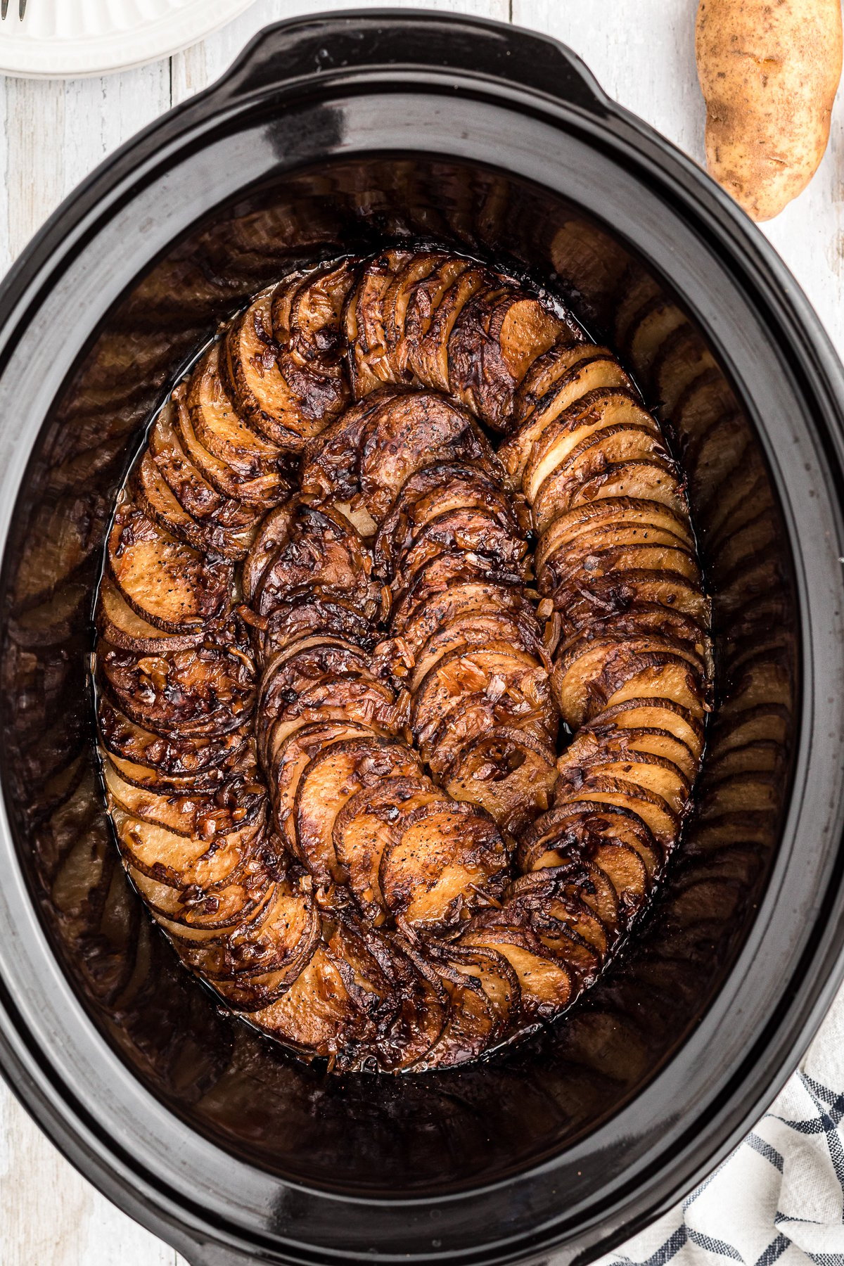 Lipton onion potatoes in a black slow cooker.