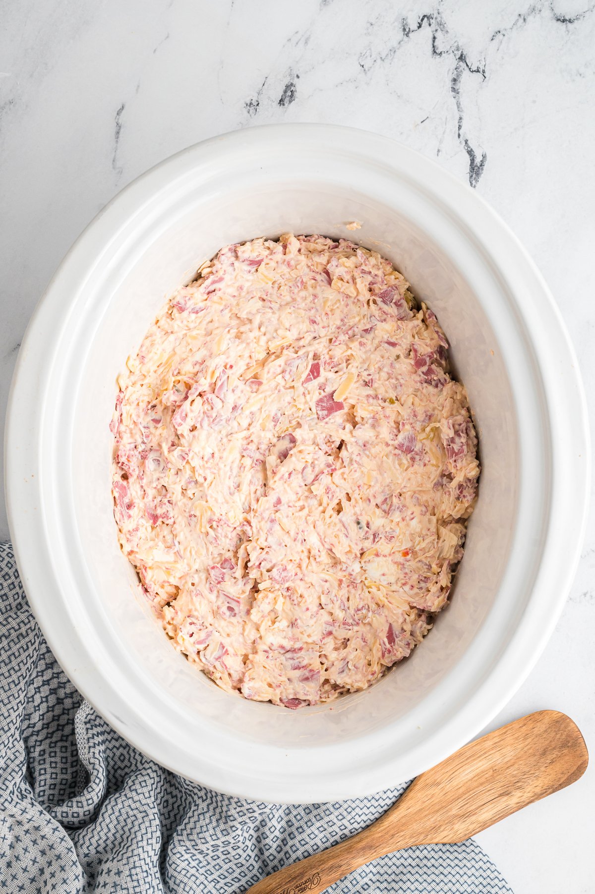 Uncooked Reuben dip in a crockpot.