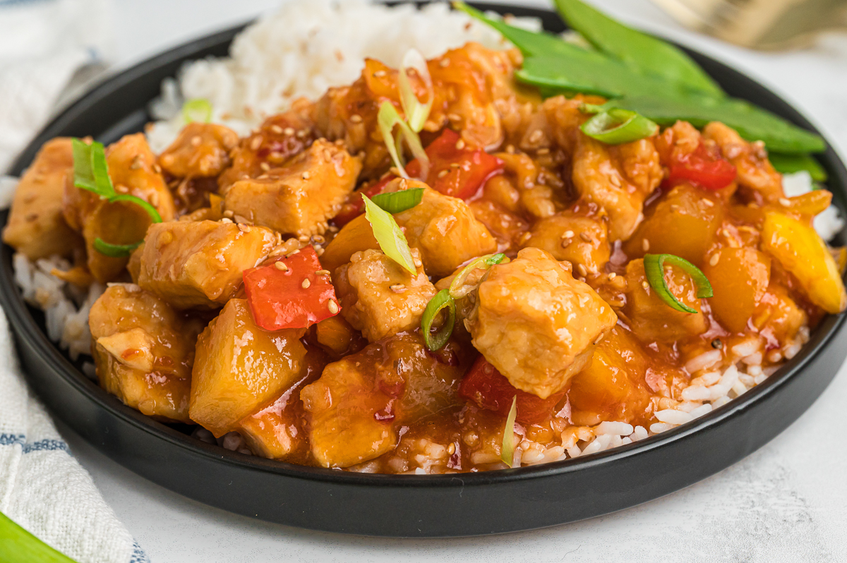 plate with sweet and sour chicken and rice on it.