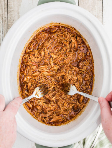 2 forks shredding apricot chicken.