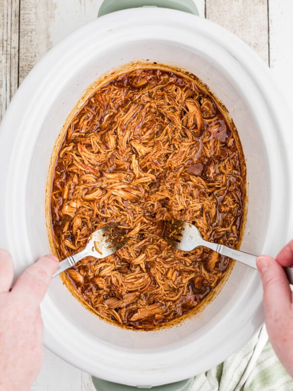 2 forks shredding apricot chicken.