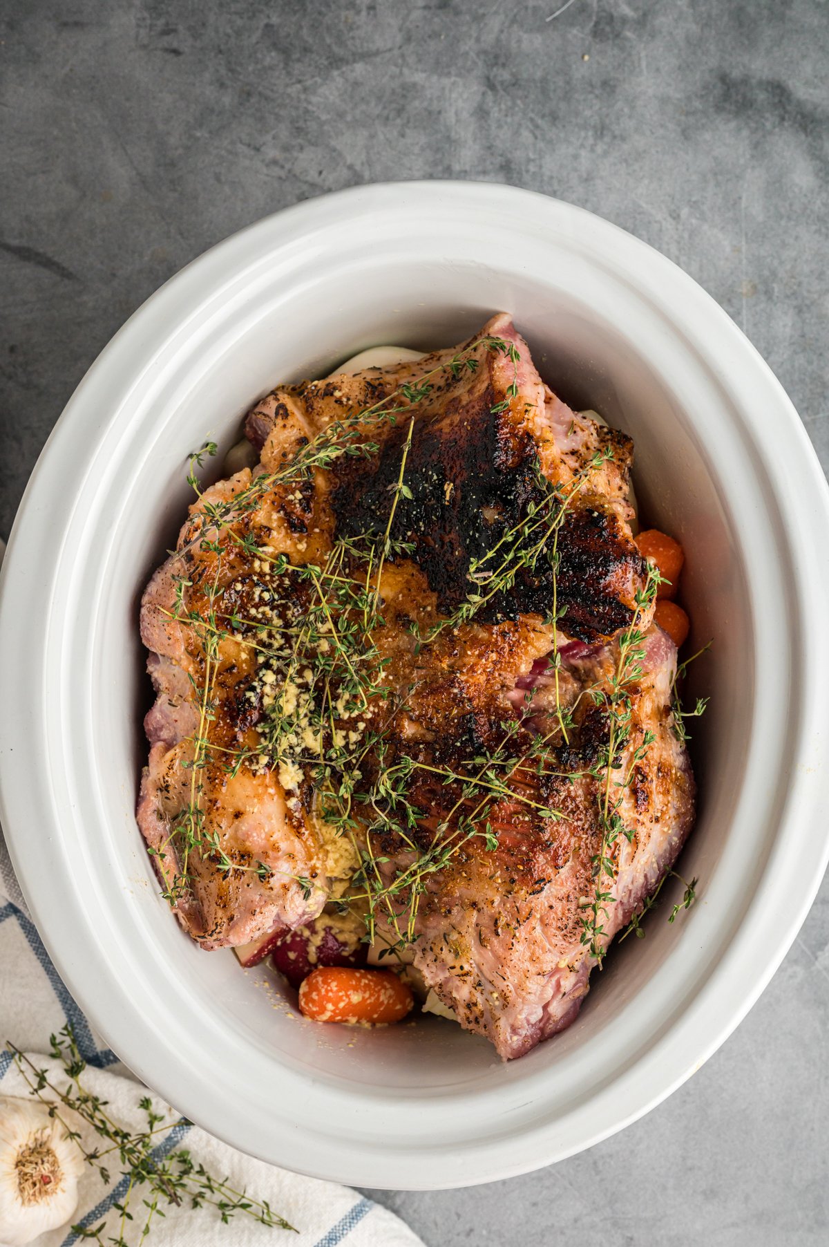 pork roast, veggies and thyme in a slow cooker.