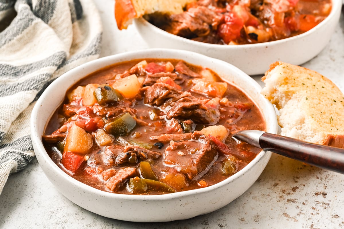 Bowl of hungarian goulash with bread on the side.