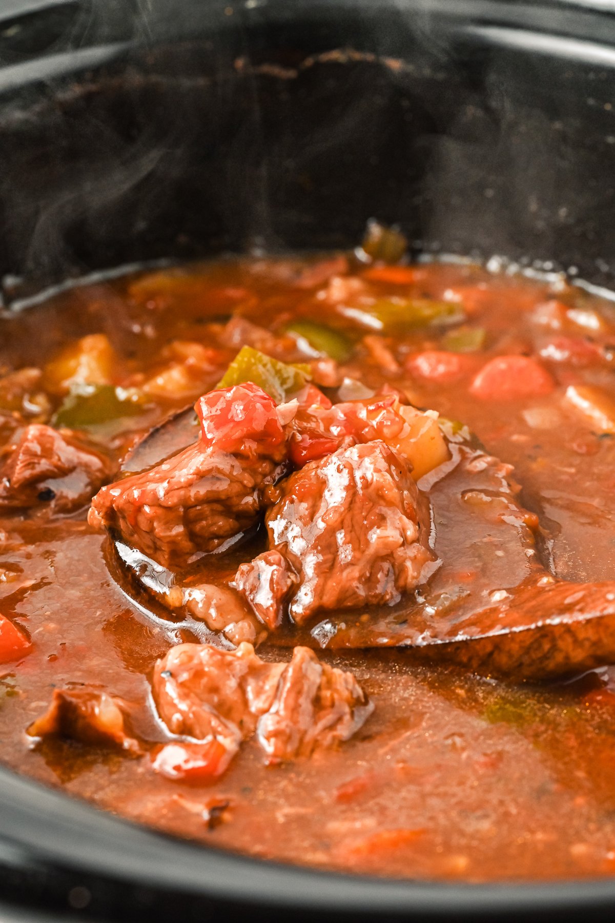 goulash on a wooden spoon.