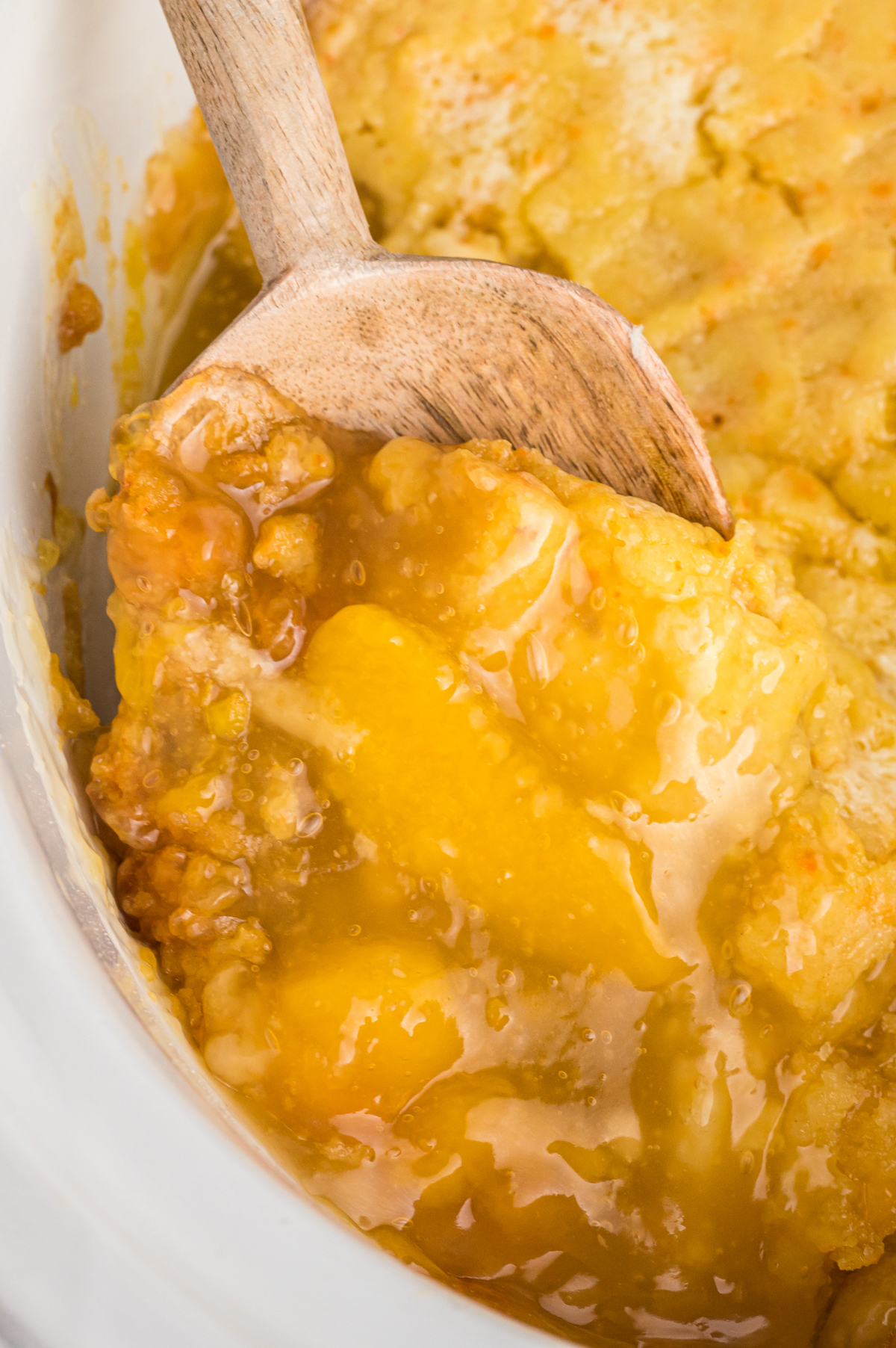 peach cobbler on a wooden spoon.