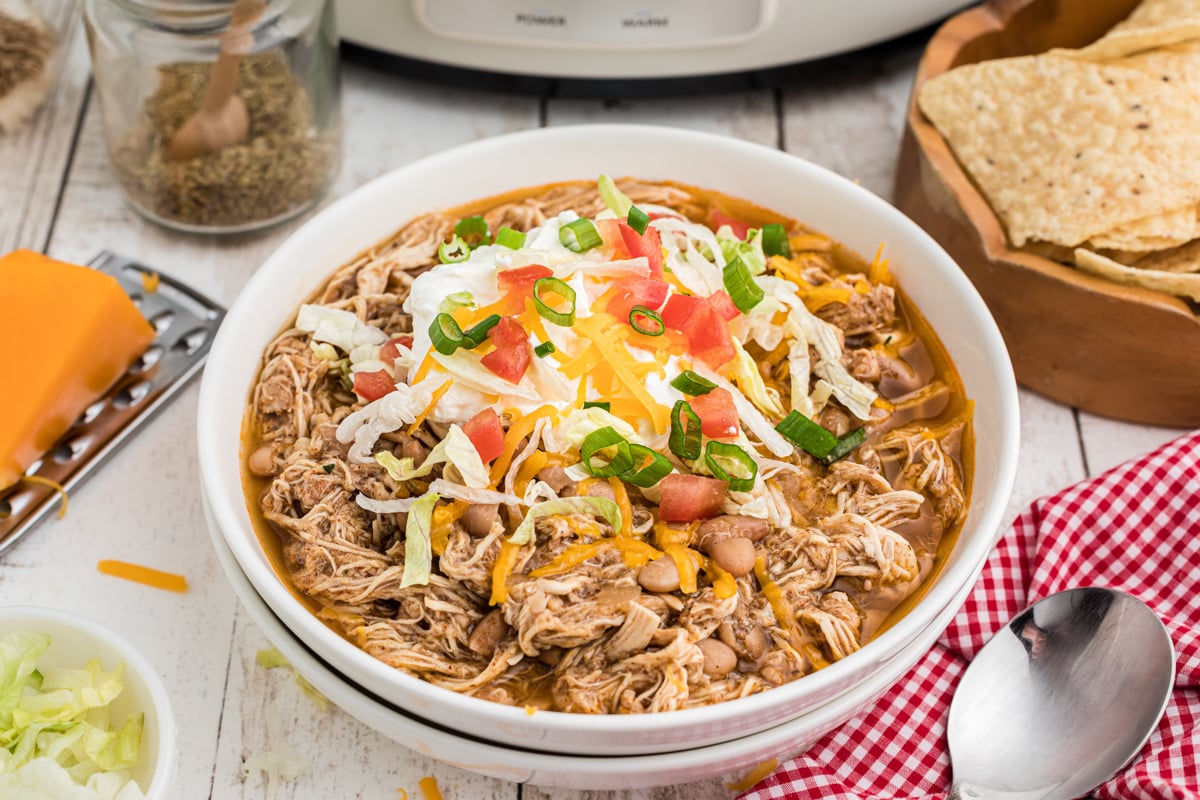 Bowl of chicken and beans with sour cream and tomatoes.