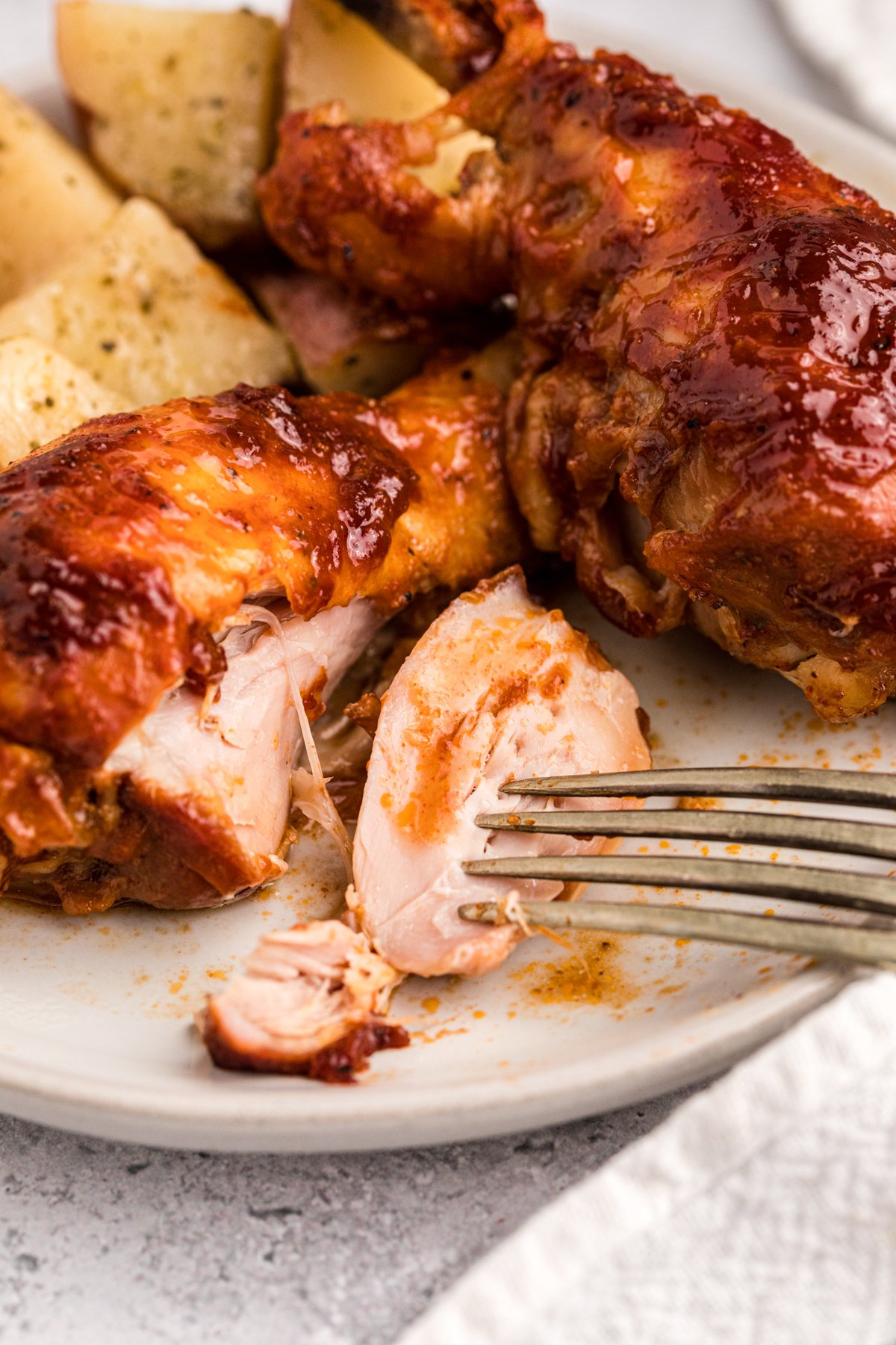 barbecue chicken potatoes and potatoes on a plate.