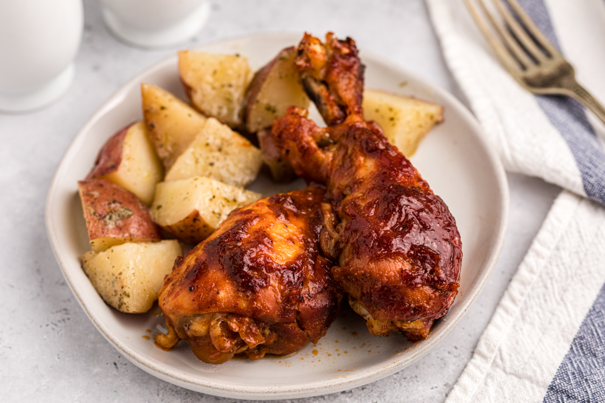 Plate of bbq chicken drumsticks with ranch potatoes.
