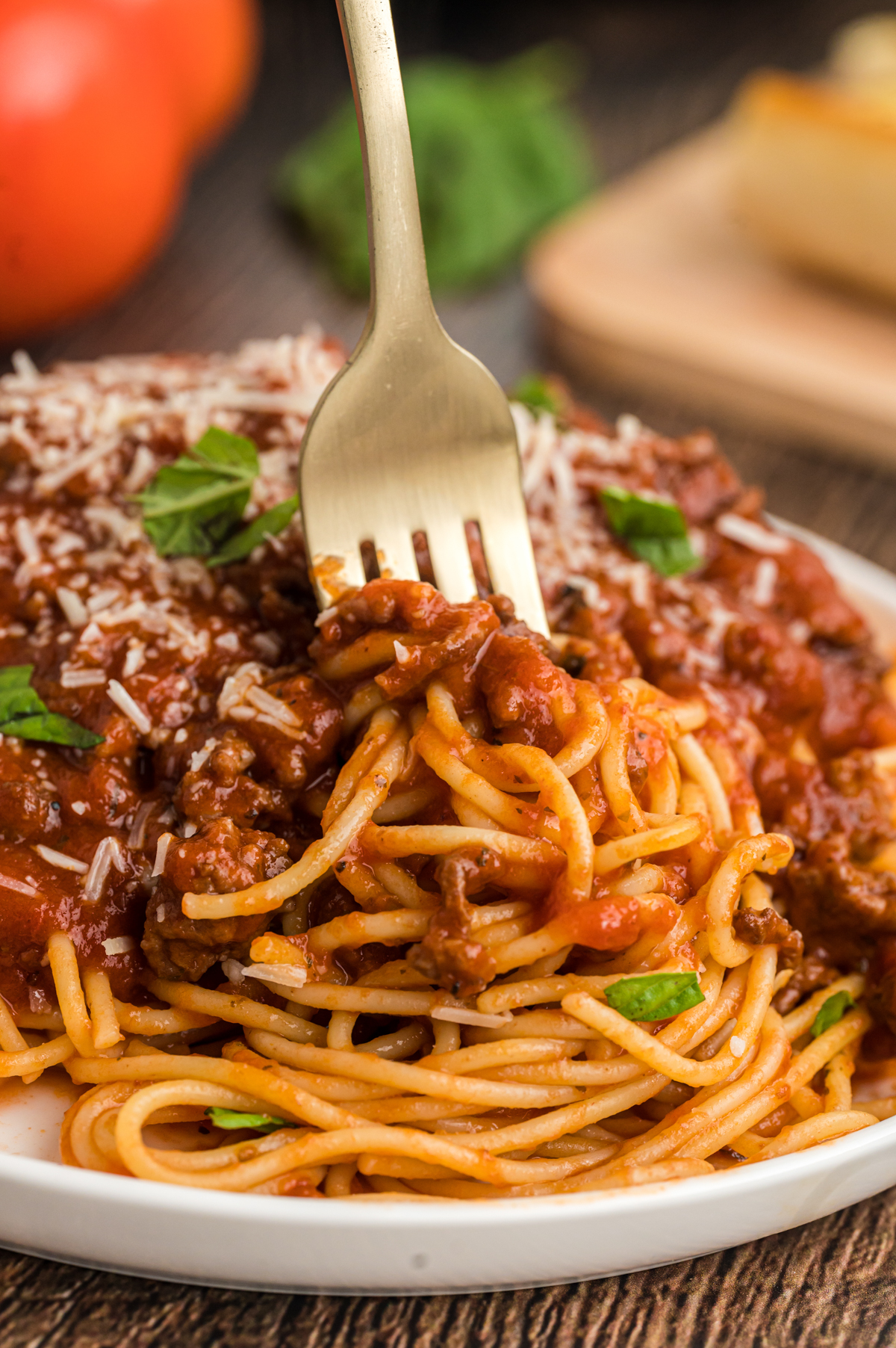 Spaghetti bolognese on a plate with a fork in it.