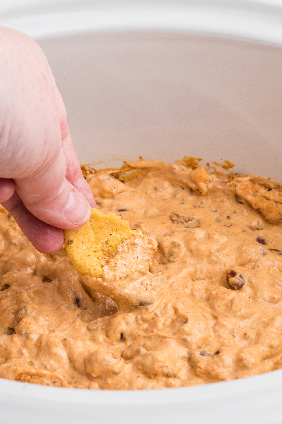 Chili cream cheese dip on a large frito.