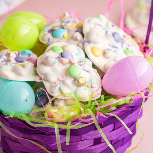 Basket filled with peanut clusters and plastic easter eggs.