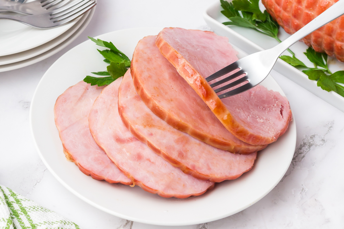 slices of ham on a platter with a fork.