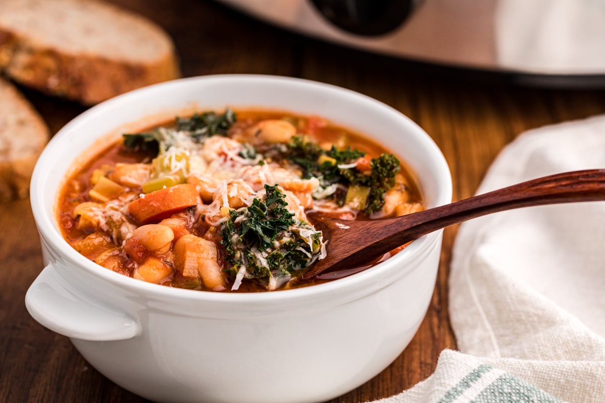 bowl of ribollita soup with small wooden spoon in it.