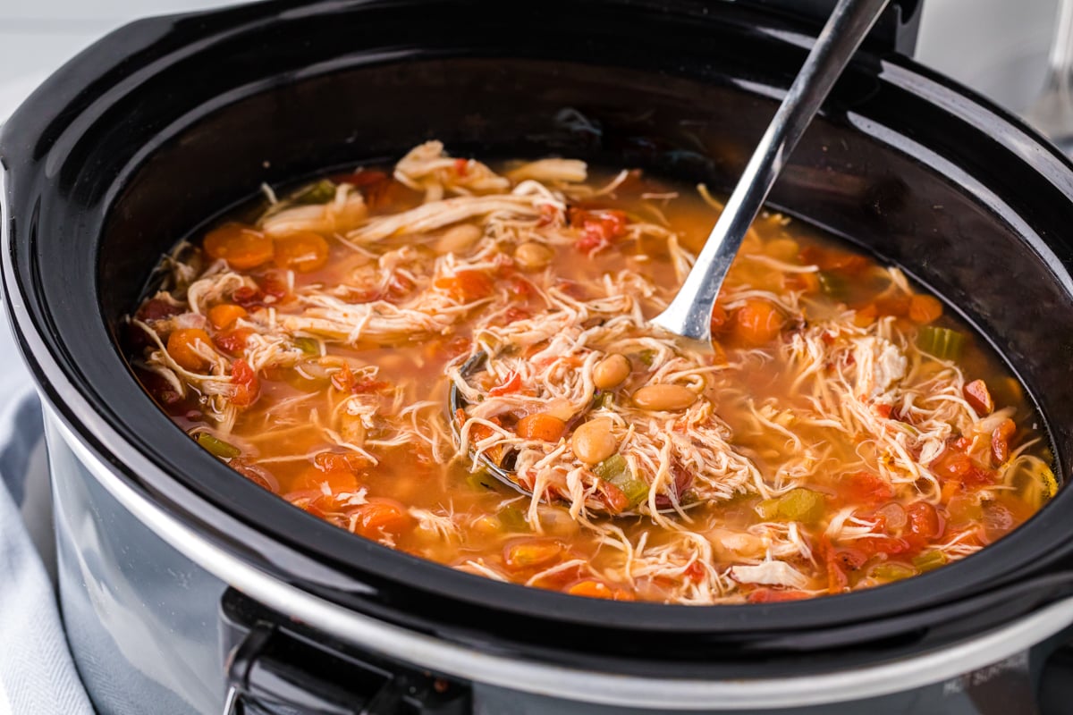 side view of tuscan bean soup in a slow cooker.