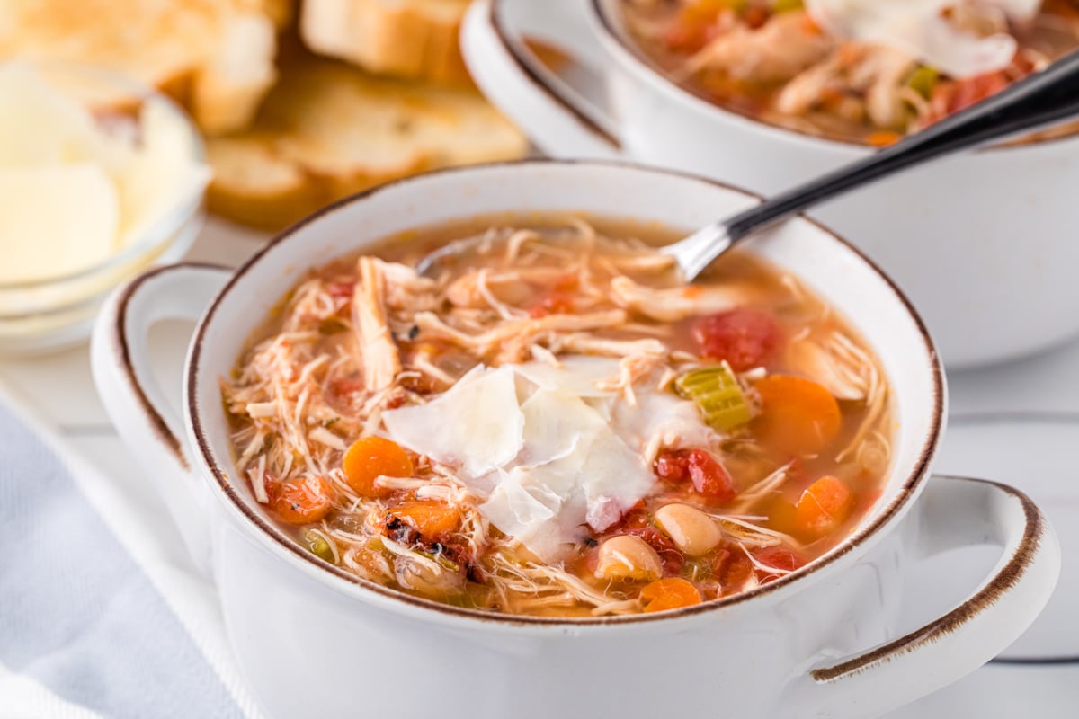 Bowl of tuscan bean soup with parmesan cheese on top.