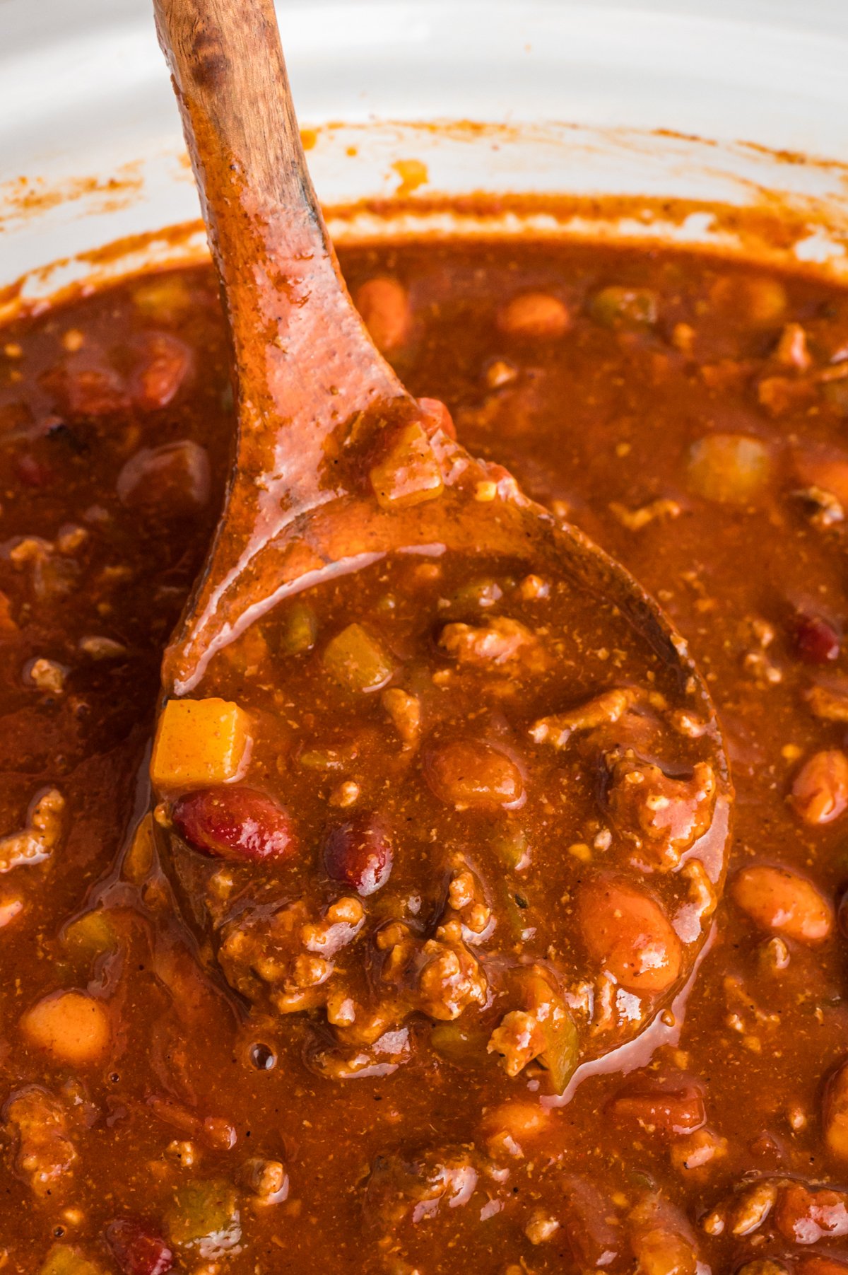 Close up of wendy's style chili on a wooden spoon.