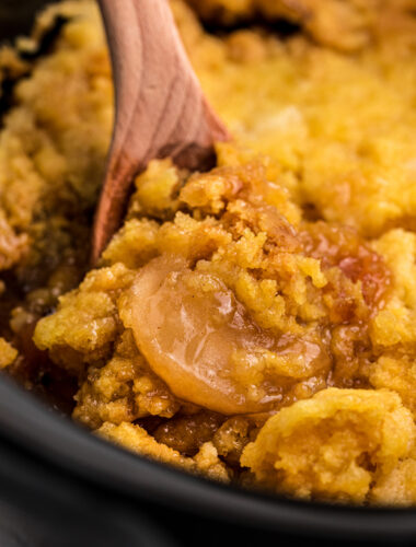 Apple cake in a black slow cooker.