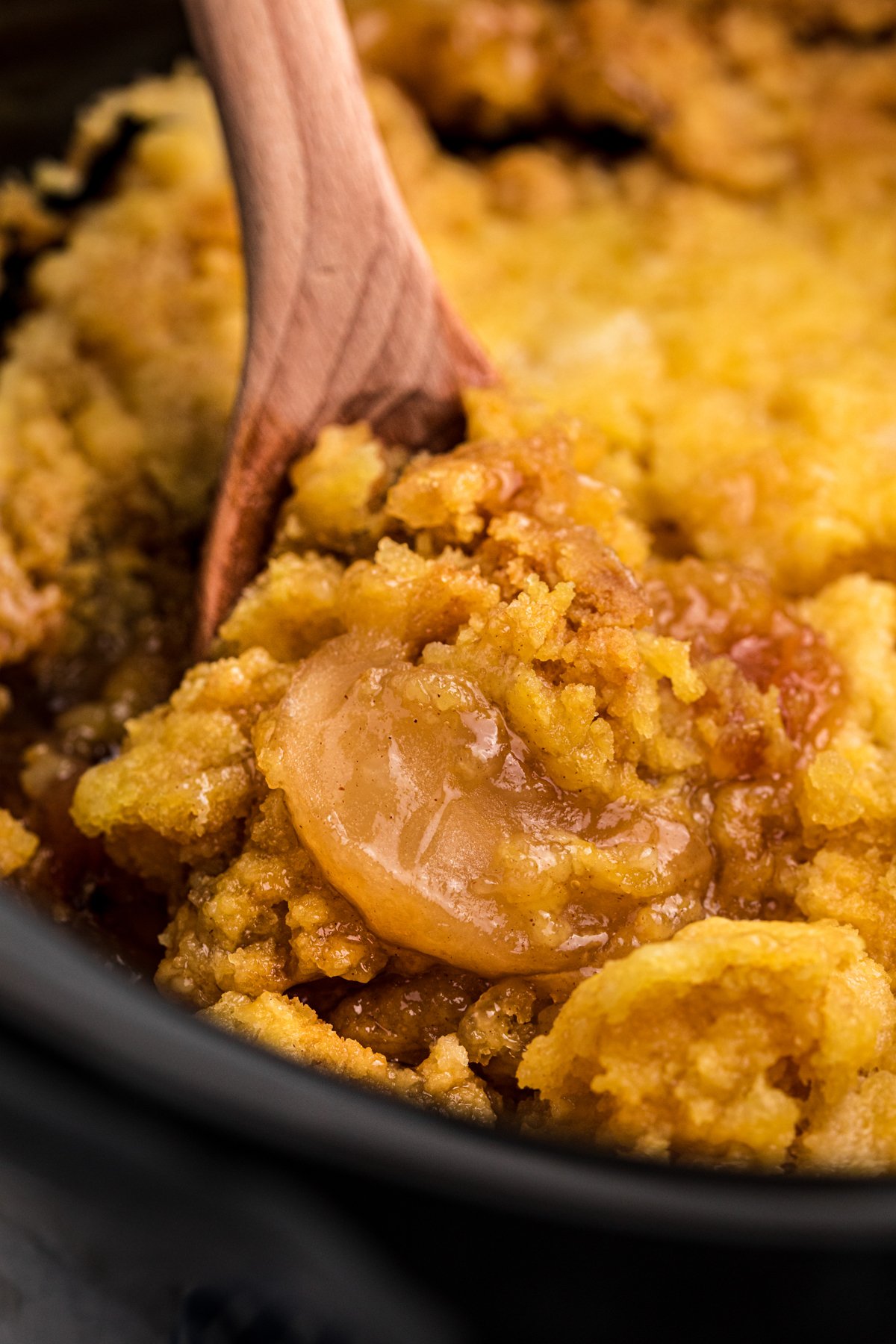 Apple cake in a black slow cooker.