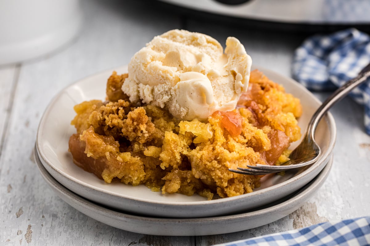 Apple dump cake with ice cream on a plate.