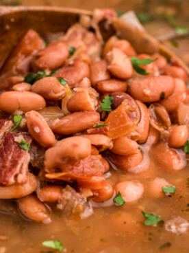 close up of charro bean on a wooden spoon.