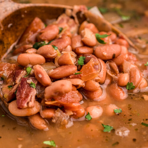 close up of charro bean on a wooden spoon.