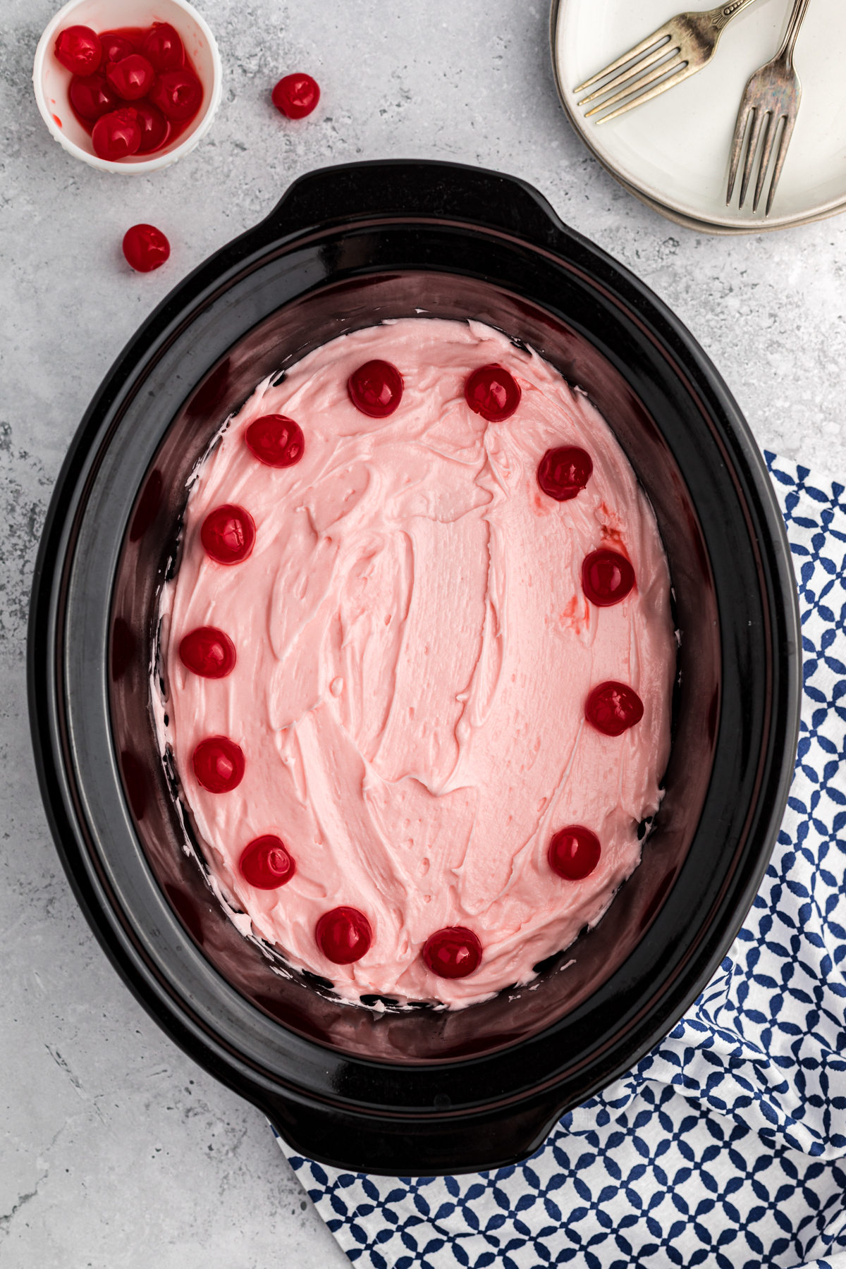 Cherry cake with frosting in a slow cooker.