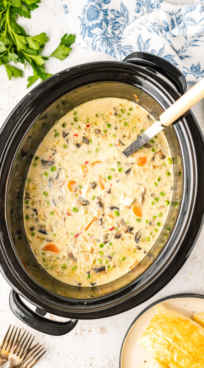 long image of chicken ala king sauce in a crockpot.