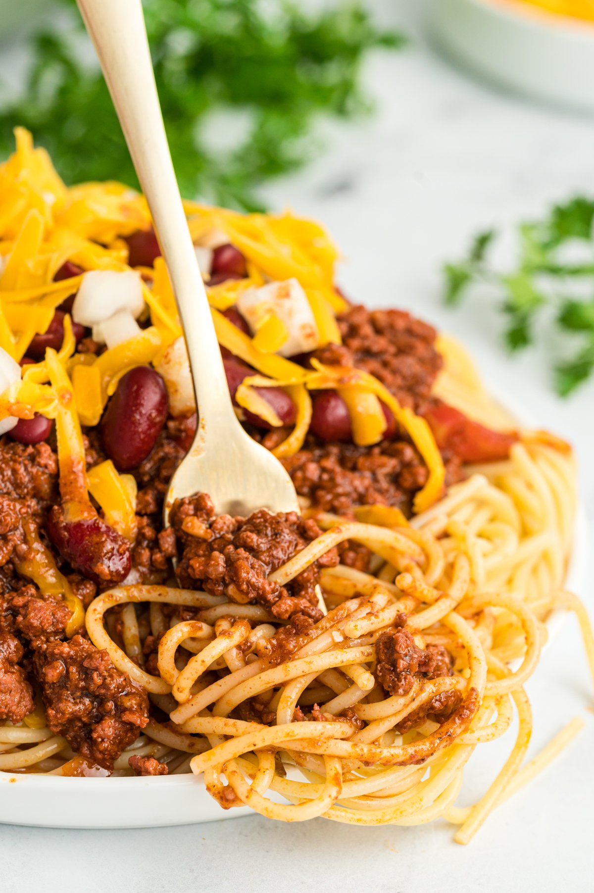 Cincinnati chili on a plate with a fork in it.