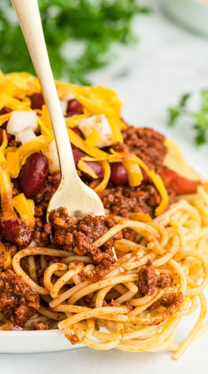 close up of cincinnati chili with a fork in it.