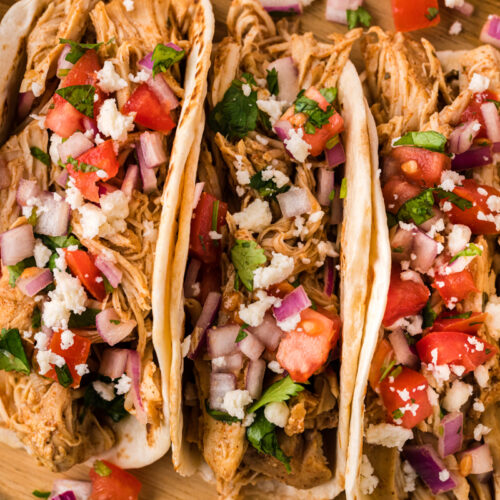 close up of tacos on a cutting board.