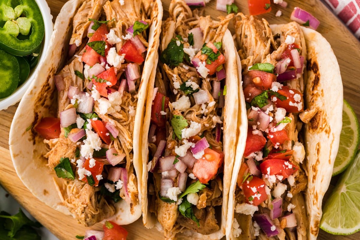 close up of tacos on a cutting board.