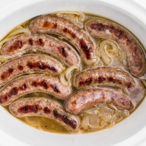 close up of beer brats in a slow cooker.