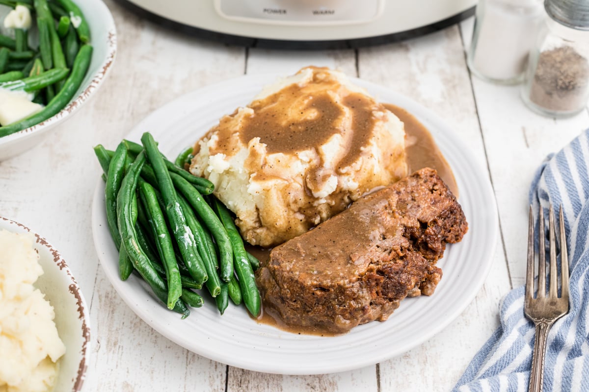 Plate of meatloaf mashed potatoes and green beans.