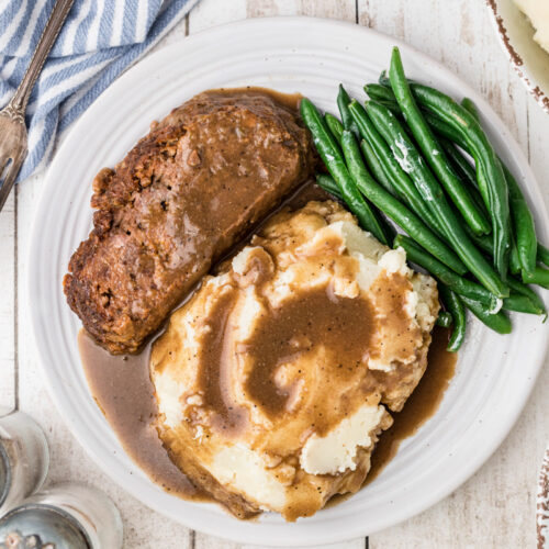 lipton meatloaf on a plate with mashed potatoes and green beans.