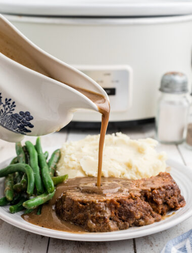 Gravy being pour over lipton onion meatloaf.