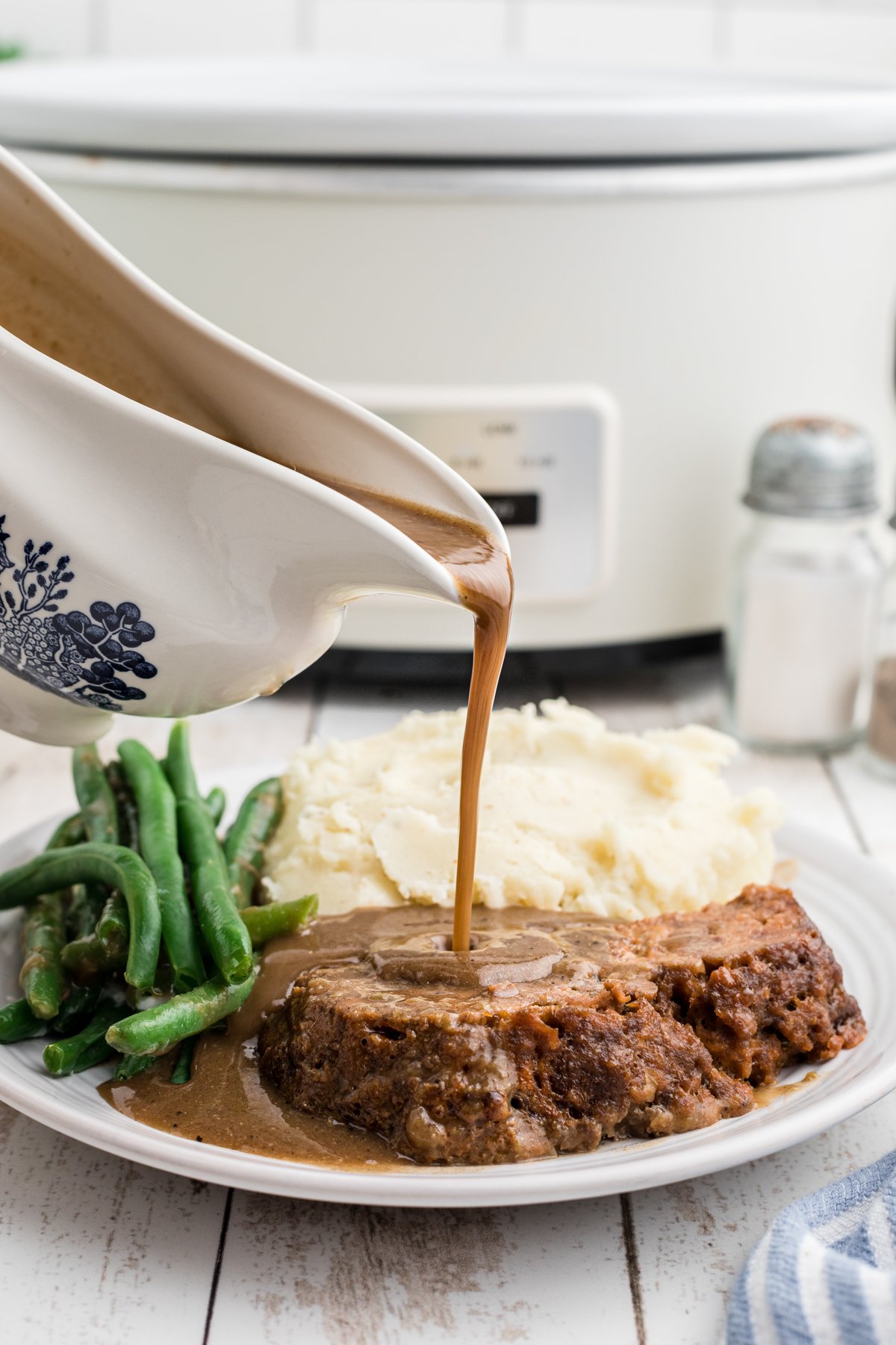 Gravy being pour over lipton onion meatloaf.