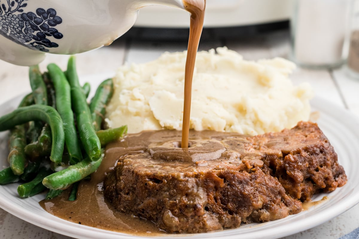 gravy being poured over lipton onion meatloaf.